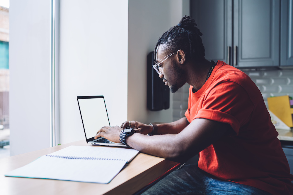 Smart black man working on laptop